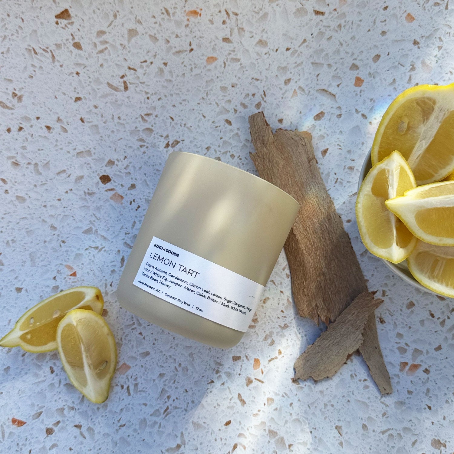 Lemon Tart wooden wick candle on a white background with lemons.