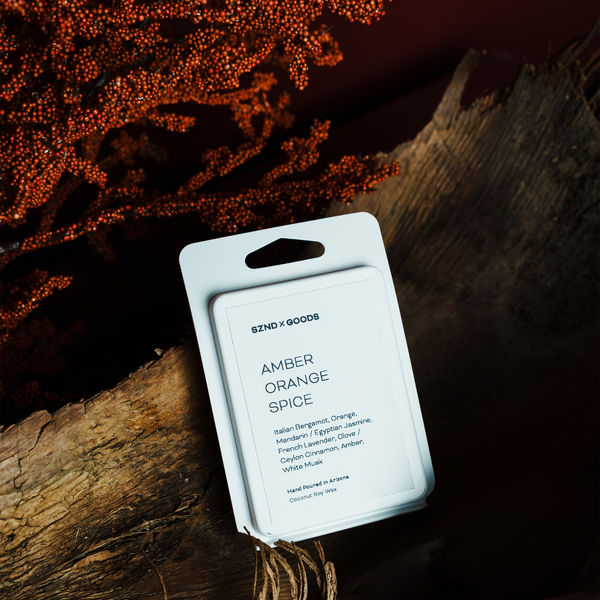 Packaged product labeled 'Amber Orange Spice' by 8NDXGOODS on a dark background with a wooden log.