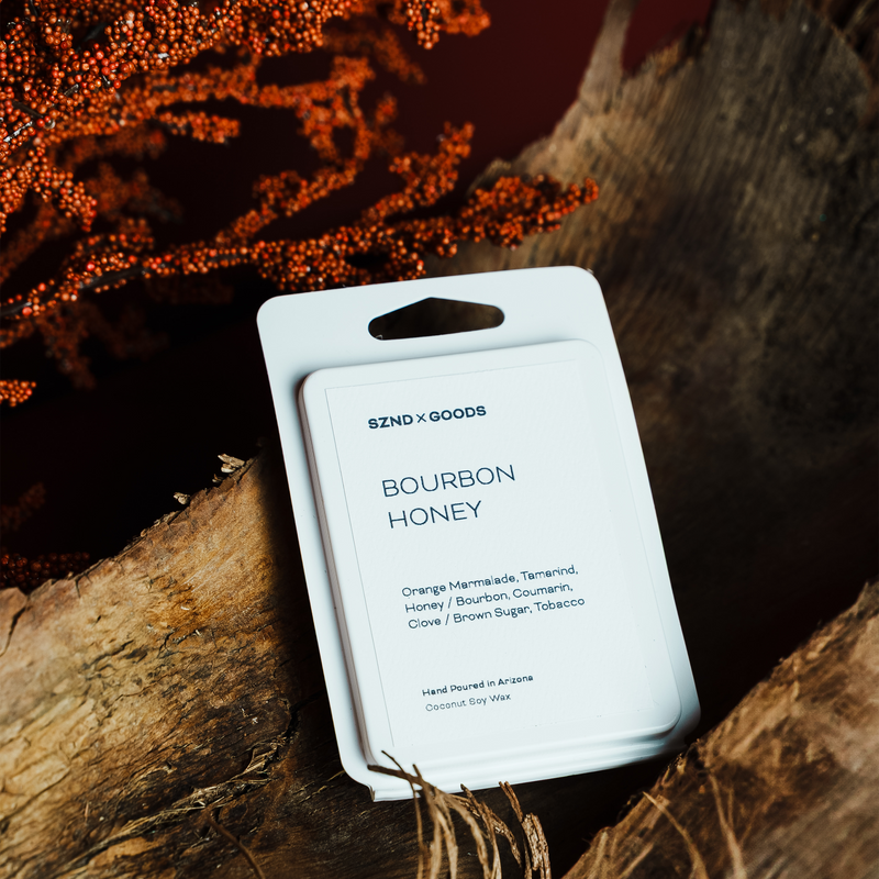 Scented product packaging labeled 'Bourbon Honey' by SZNDSXGOODS on a wooden surface.