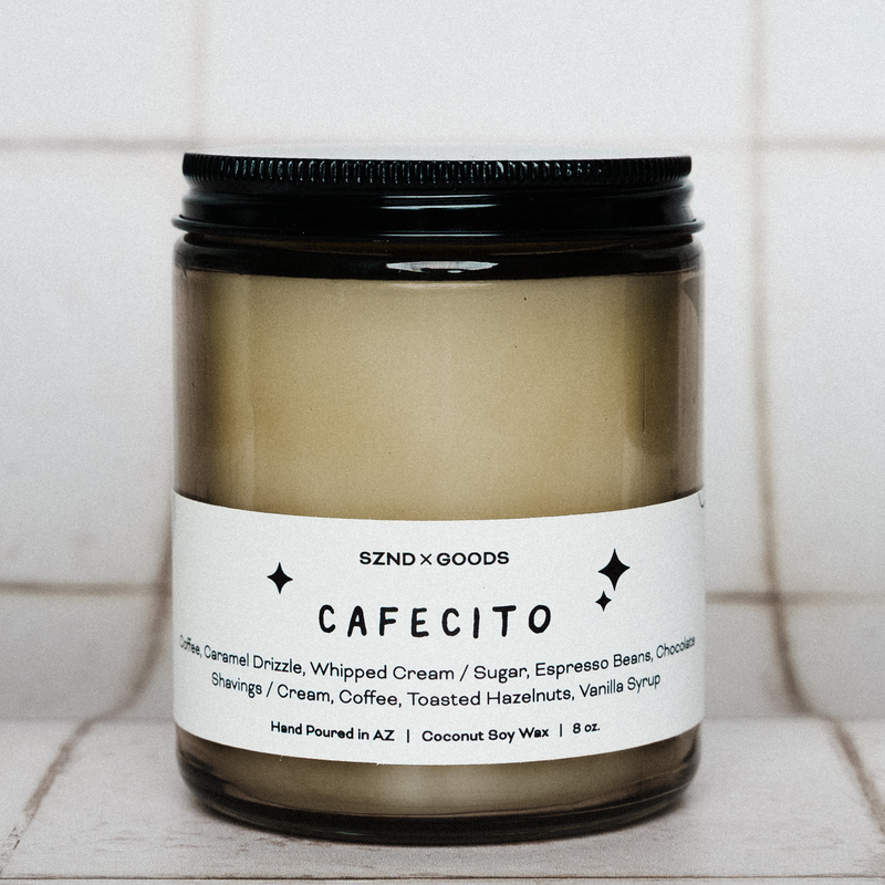 Candle labeled 'CAFECITO' with a black lid on a tiled surface.