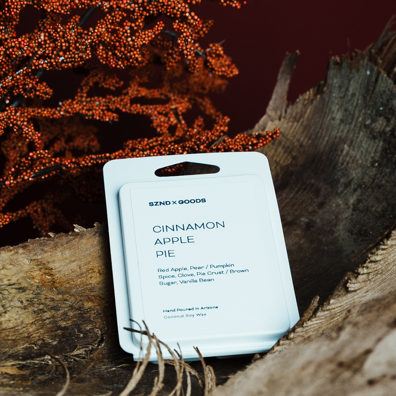 Packaged cinnamon apple pie candle with a natural wood background