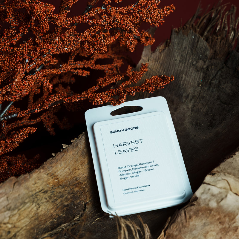 Product packaging labeled 'Harvest Leaves' on a wooden surface with autumn leaves.