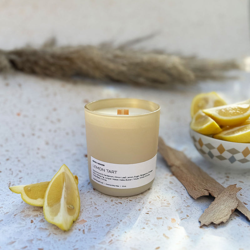 Lemon Tart candle on a white background with lemon and wood props.