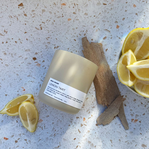 Lemon Tart wooden wick candle on a white background with lemons.