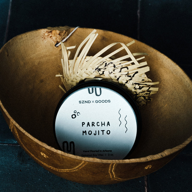 Mini candle labeled 'Parcha Mojito' with decorative elements on a dark background.