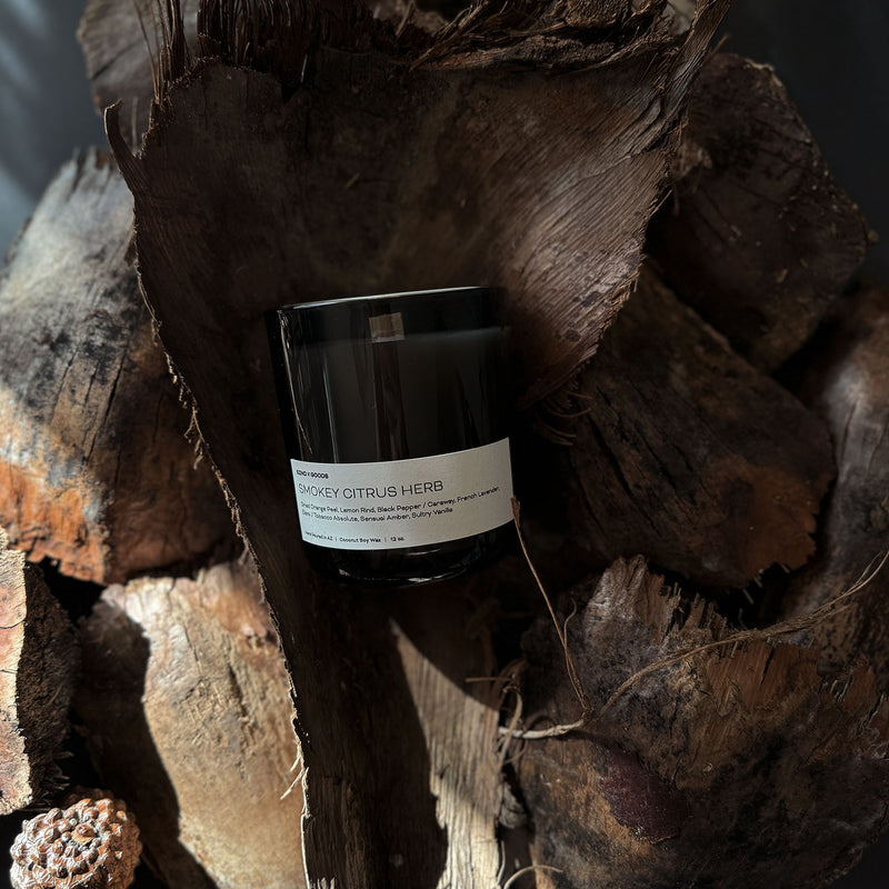 Smokey Citrus Herb wooden wick candle placed on a wood piece.