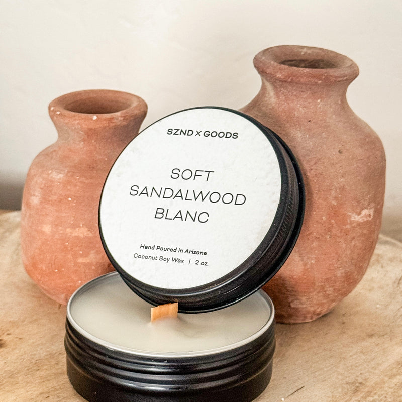 Candle labeled 'Soft Sandalwood Blanc' with two terracotta vases in the background.