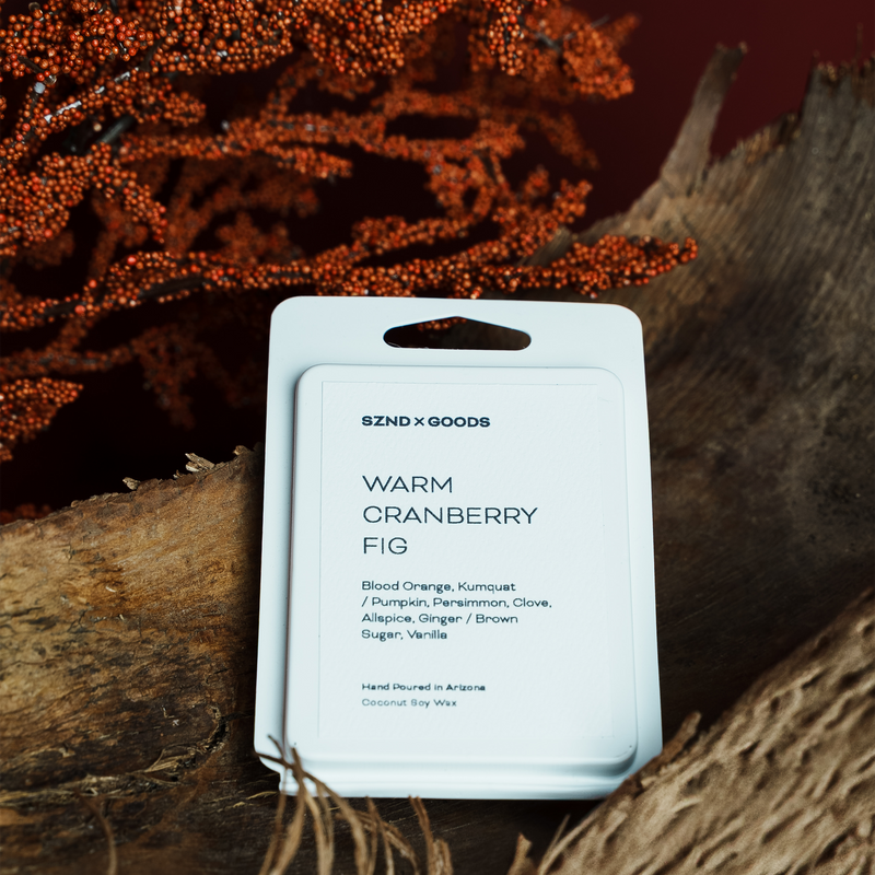 Packaged wax melt labeled 'Warm Cranberry Fig' with a natural wood and berry background.
