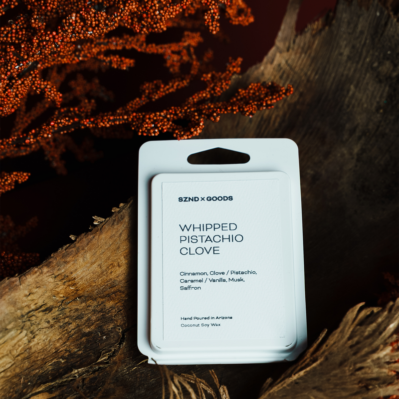 Packaged product labeled 'Whipped Pistachio Clove' on a wooden surface with a dark background.