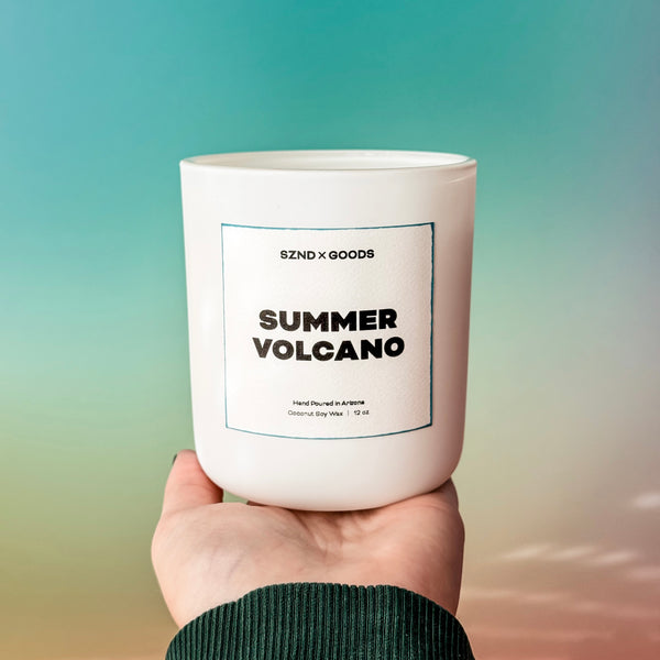 Summer Volcano wooden wick candle on a bright background in a hand.